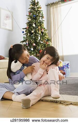 Two sisters (10-11) in front of christmas tree View Large Photo Image Stock Photograph - Two sisters (10-11) in front of christmas tree. Fotosearch