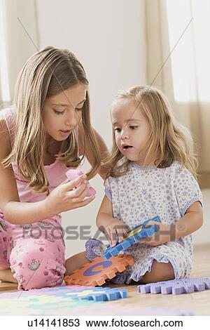 Two sisters playing together View Large Photo Image Stock Image - Two sisters playing together. Fotosearch
