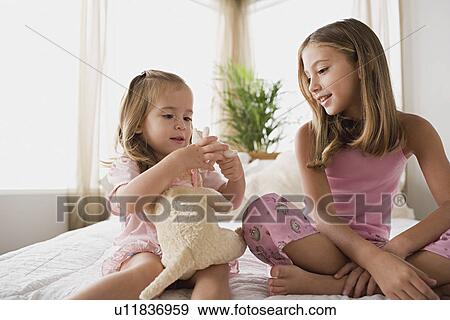 Two sisters playing together View Large Photo Image Stock Photo - Two sisters playing together. Fotosearch