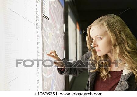 Stock Image - USA, California, Los Angeles, Woman at subway station checking map. Fotosearch