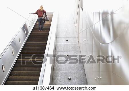Picture - USA, California, Los Angeles, Woman on escalator in subway station. Fotosearch