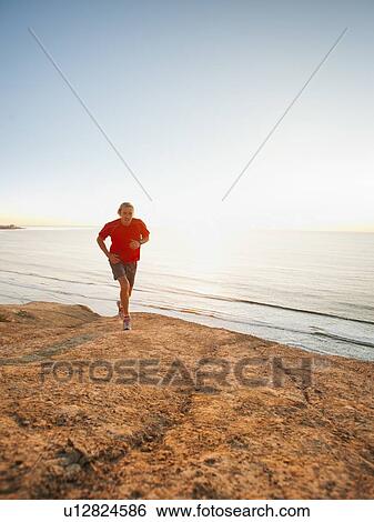 USA, California, San Diego, Man jogging along sea coast View Large Photo Image Stock Photograph - USA, California, San Diego, Man jogging along sea coast. Fotosearch