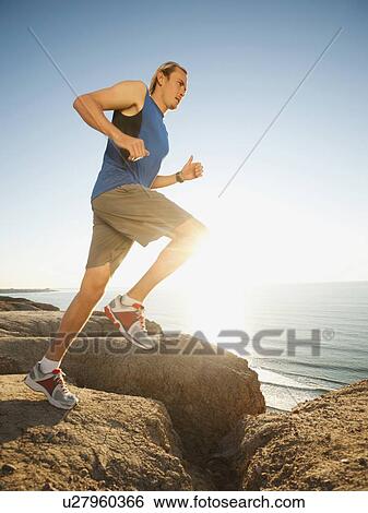 USA, California, San Diego, Man jogging along sea coast View Large Photo Image Stock Photograph - USA, California, San Diego, Man jogging along sea coast. Fotosearch