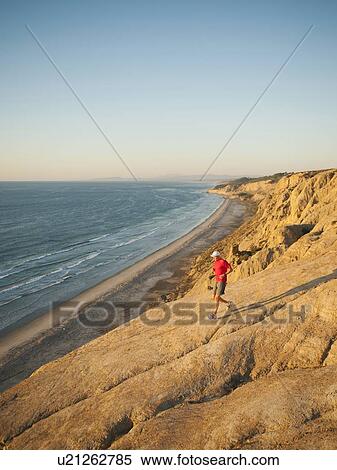 USA, California, San Diego, Man jogging along sea coast View Large Photo Image Stock Photography - USA, California, San Diego, Man jogging along sea coast. Fotosearch