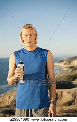 USA, California, San Diego, Portrait of male jogger holding water bottle View Large Photo Image Stock Image - USA, California, San Diego, Portrait of male jogger holding water bottle. Fotosearch