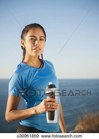 USA, California, San Diego, Portrait of female jogger holding water bottle View Large Photo Image Stock Photo - USA, California, San Diego, Portrait of female jogger holding water bottle. Fotosearch