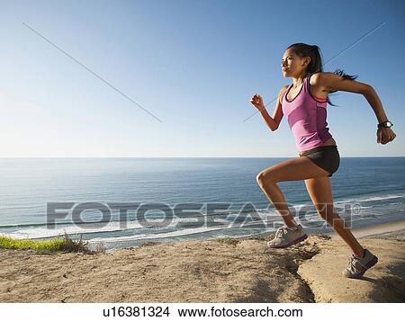 USA, California, San Diego, Woman jogging along sea coast View Large Photo Image Picture - USA, California, San Diego, Woman jogging along sea coast. Fotosearch