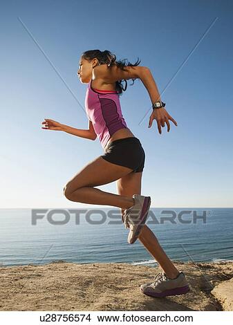 USA, California, San Diego, Woman jogging along sea coast View Large Photo Image Picture - USA, California, San Diego, Woman jogging along sea coast. Fotosearch