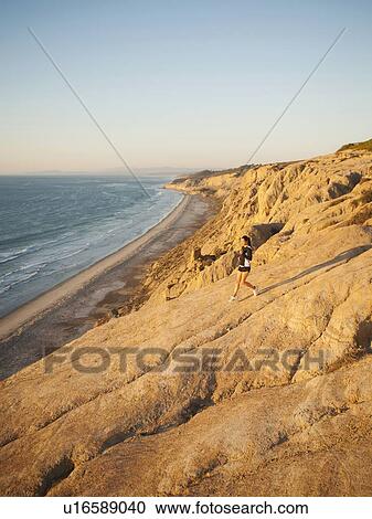 USA, California, San Diego, Woman jogging along sea coast View Large Photo Image Stock Image - USA, California, San Diego, Woman jogging along sea coast. Fotosearch