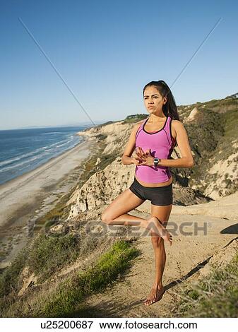 Stock Photo - USA, California, San Diego, Woman practicing yoga on beach. Fotosearch