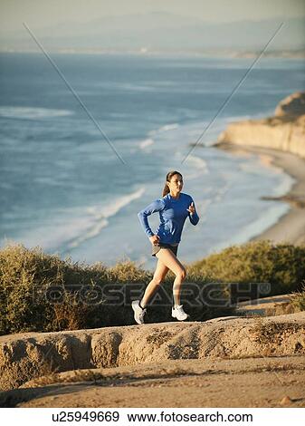 USA, California, San Diego, Woman jogging along sea coast View Large Photo Image Stock Photo - USA, California, San Diego, Woman jogging along sea coast. Fotosearch