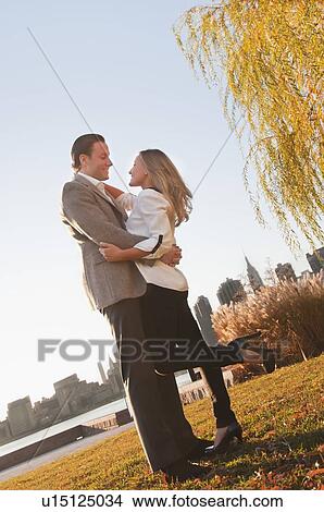 USA, New York, Long Island City, Young couple embracing in park View Large Photo Image Picture - USA, New York, Long Island City, Young couple embracing in park. Fotosearch