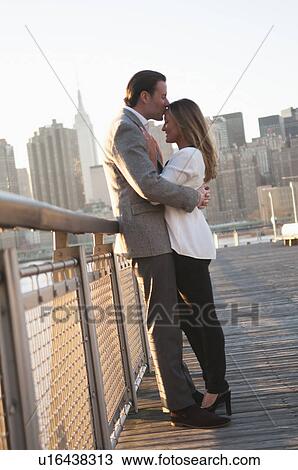 USA, New York, Long Island City, Young couple kissing on boardwalk, Manhattan skyline in background View Large Photo Image Stock Image - USA, New York, Long Island City, Young couple kissing on boardwalk, Manhattan skyline in background. Fotosearch