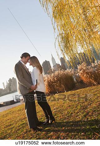 USA, New York, Long Island City, Young couple standing in park View Large Photo Image Stock Image - USA, New York, Long Island City, Young couple standing in park. Fotosearch