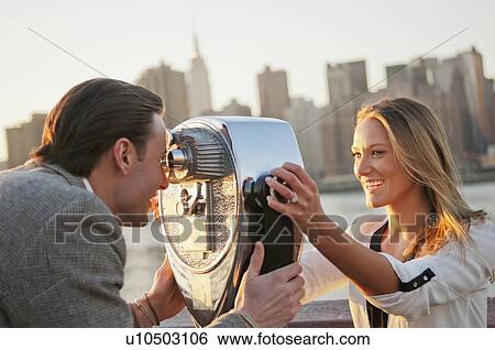 USA, New York, Long Island City, Young couple looking through coin operated binoculars, Manhattan skyline in background View Large Photo Image Stock Photograph - USA, New York, Long Island City, Young couple looking through coin operated binoculars, Manhattan skyline in background. Fotosearch