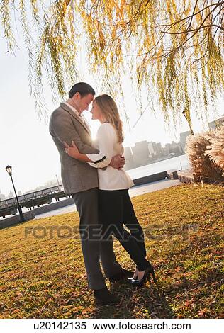 USA, New York, Long Island City, Young couple embracing in park View Large Photo Image Stock Photography - USA, New York, Long Island City, Young couple embracing in park. Fotosearch