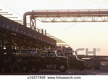 Stock Photo - USA, New York, New York City, Trucks loading in oil plant. Fotosearch