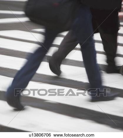 Stock Photograph - USA, New York state, New York city, low section of men crossing zebra crossing . Fotosearch