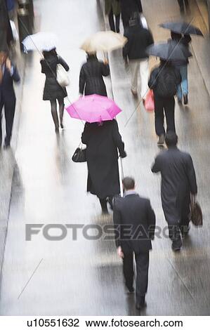 Stock Image - USA, New York state, New York city, pedestrians walking with umbrellas. Fotosearch