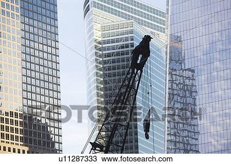 Stock Image - Usa, New York State, New York City, crane's hook in front of skyscraper. Fotosearch