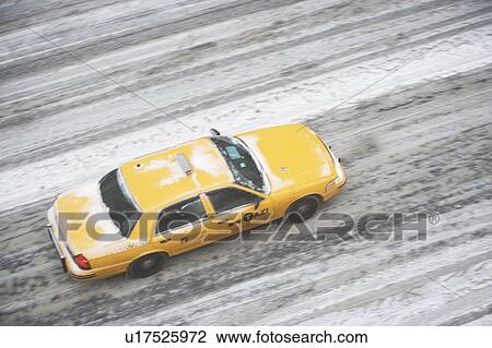 Stock Image - USA, New York State, New York City, blurred motion of yellow taxi. Fotosearch