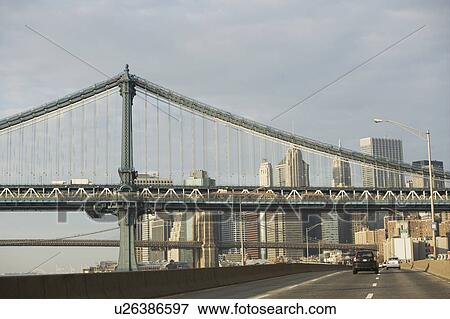 Stock Photo - Usa, New York State, New York City, city street with view at bridge. Fotosearch