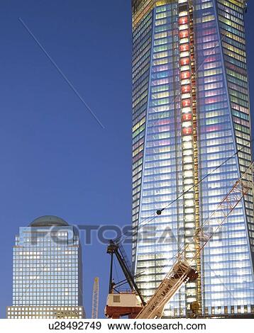 Stock Photo - USA, New York State, New York City, crane in front of illuminated skyscrapers. Fotosearch