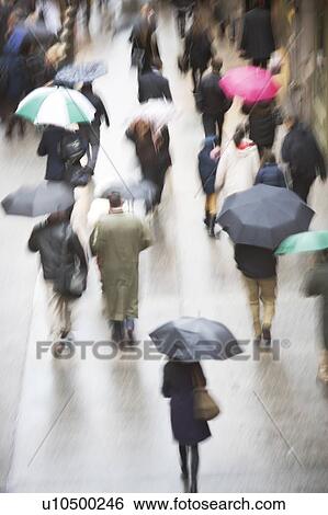 Stock Photograph - USA, New York state, New York city, pedestrians walking with umbrellas. Fotosearch