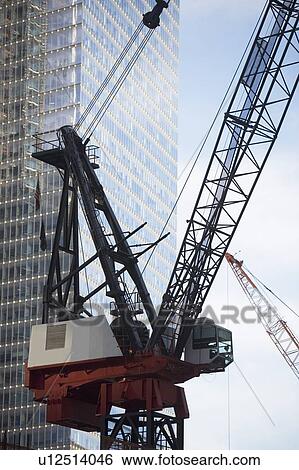 Stock Photograph - Usa, New York State, New York City, crane in front of skyscraper. Fotosearch