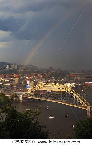 Stock Image - USA, Pennsylvania, Pittsburgh, Rainbow above bridge. Fotosearch