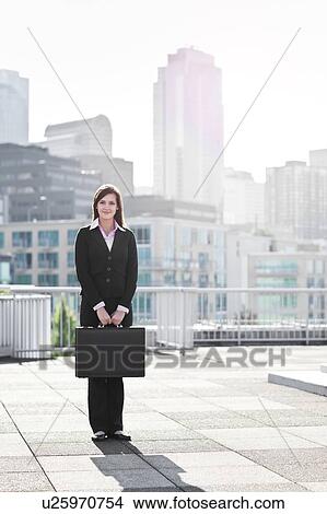 USA, Seattle, Smiling young businesswoman holding briefcase View Large Photo Image Picture - USA, Seattle, Smiling young businesswoman holding briefcase. Fotosearch