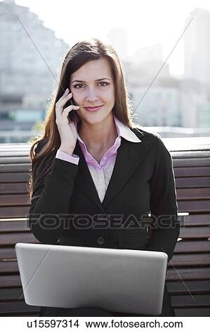 USA, Seattle, Young businesswoman sitting on bench and working View Large Photo Image Picture - USA, Seattle, Young businesswoman sitting on bench and working. Fotosearch