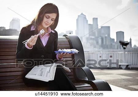 USA, Seattle, Young businesswoman eating sushi and reading newspaper View Large Photo Image Stock Image - USA, Seattle, Young businesswoman eating sushi and reading newspaper. Fotosearch