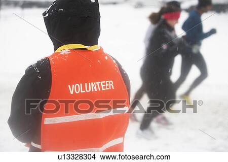 Picture - Volunteer assisting in marathon race. Fotosearch