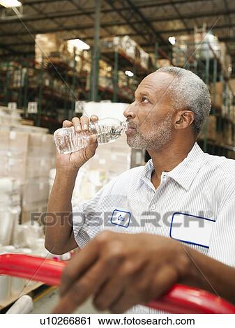 Warehouse worker drinking water View Large Photo Image Stock Image - Warehouse worker drinking water. Fotosearch