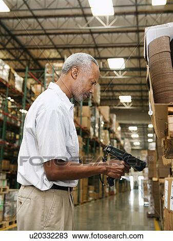 Stock Image - Warehouse worker scanning delivery. Fotosearch