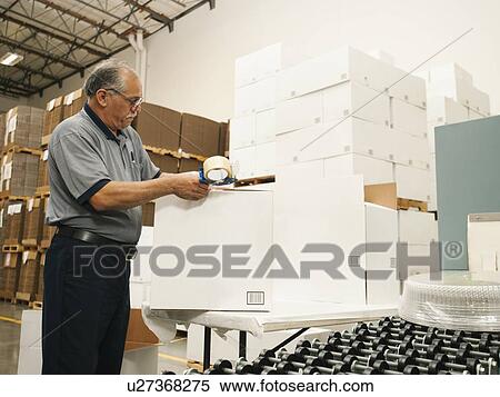 Stock Photography - Warehouse worker sealing boxes. Fotosearch