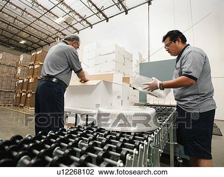 Stock Image - Warehouse workers assembling merchandise. Fotosearch