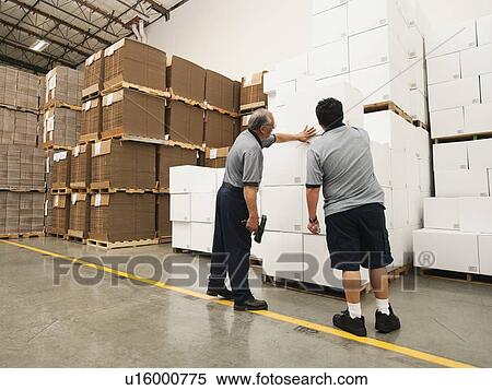 Warehouse workers inspecting delivery View Large Photo Image Stock Photography - Warehouse workers inspecting delivery. Fotosearch