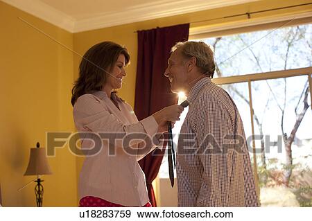 Woman helping man get dressed View Large Photo Image Stock Photo - Woman helping man get dressed. Fotosearch