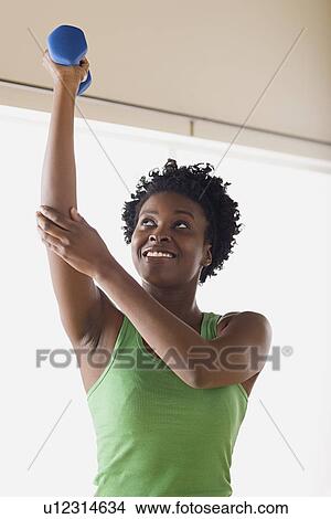 Picture - Woman lifting dumbbell. Fotosearch