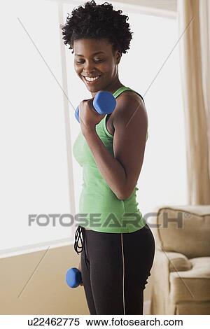 Stock Photography - Woman lifting dumbbells. Fotosearch