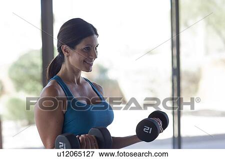 Stock Photo - Woman lifting weights. Fotosearch