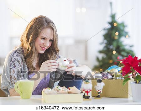 Stock Image - Woman looking at christmas decoration . Fotosearch