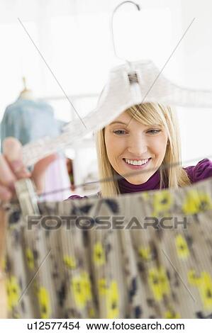 Picture - Woman looking at skirt in clothes store. Fotosearch