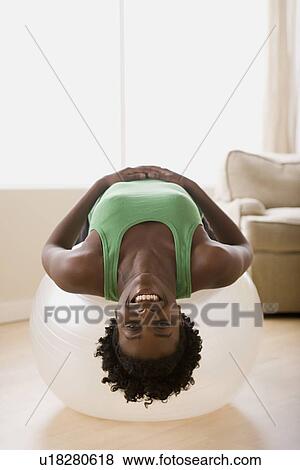 Woman lying down on fitness ball View Large Photo Image Stock Photo - Woman lying down on fitness ball. Fotosearch