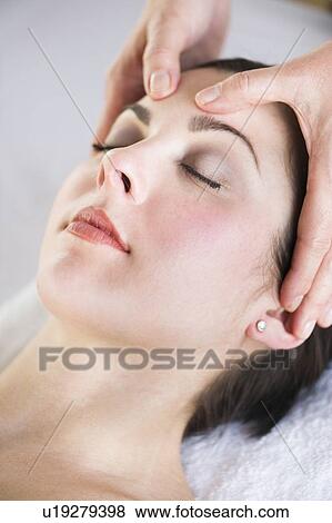 Stock Photo - Woman receiving face massage. Fotosearch