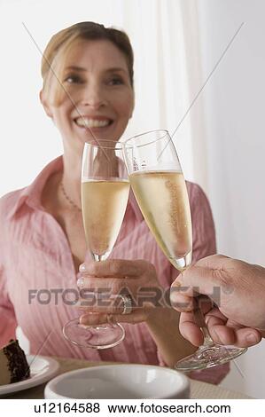 Woman toasting with glass of champagne View Large Photo Image Stock Photo - Woman toasting with glass of champagne. Fotosearch