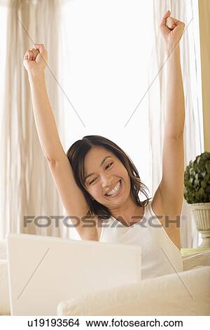 Picture - Woman using laptop at home. Fotosearch