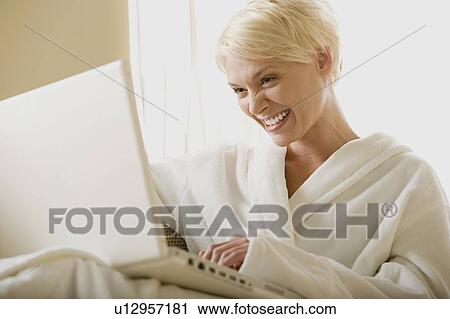 Woman using laptop at home View Large Photo Image Stock Image - Woman using laptop at home. Fotosearch